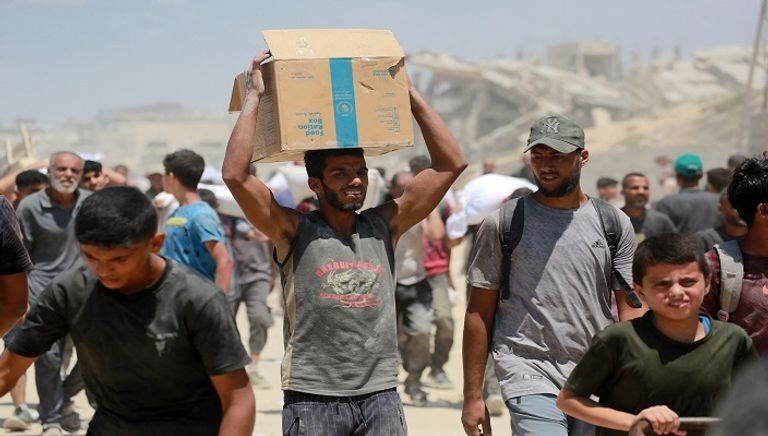 فلسطينيون يحملون أكياس الدقيق
