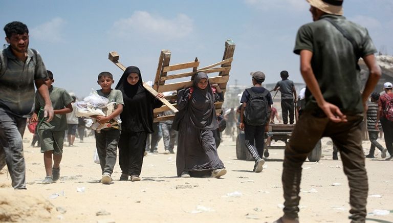 فلسطينيون يحملون أكياس الدقيق