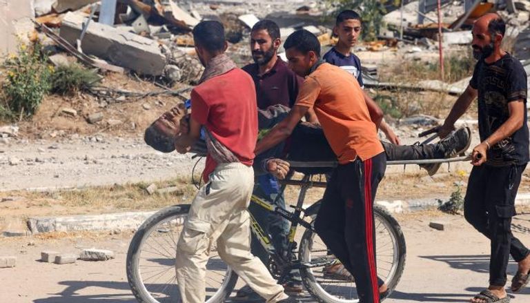 فلسطينيون يحملون جثمان قتيل على دراجة