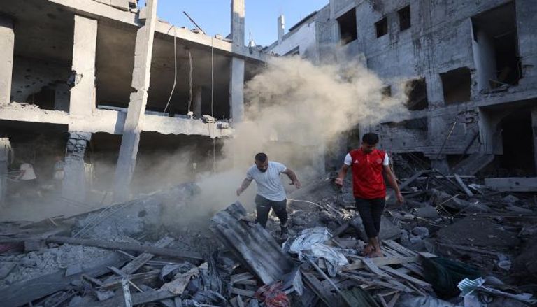 فلسطينيان يتفقدان أضرار قصف إسرائيلي في غزة