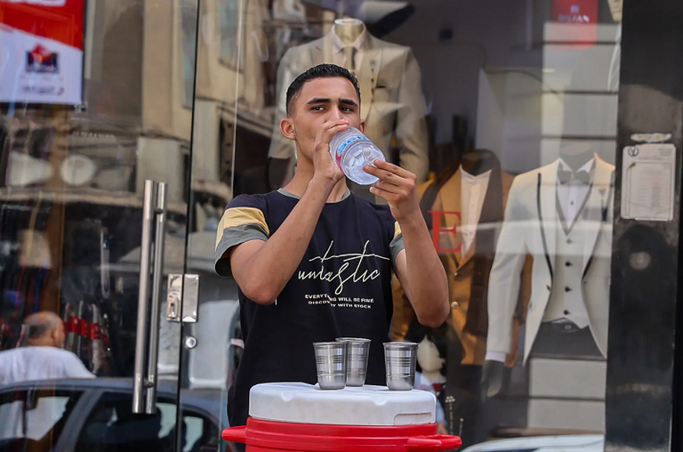 امرأتان تحتميان بمظلة من أشعة الشمس على أحد الجسور في القاهرة- أرشيفية