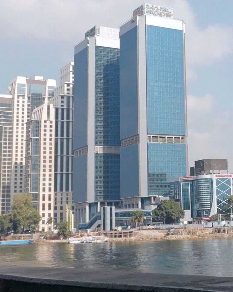 شخص سقف أمام ماكينة تابعة للبنك الأهلي المصري - رويترز