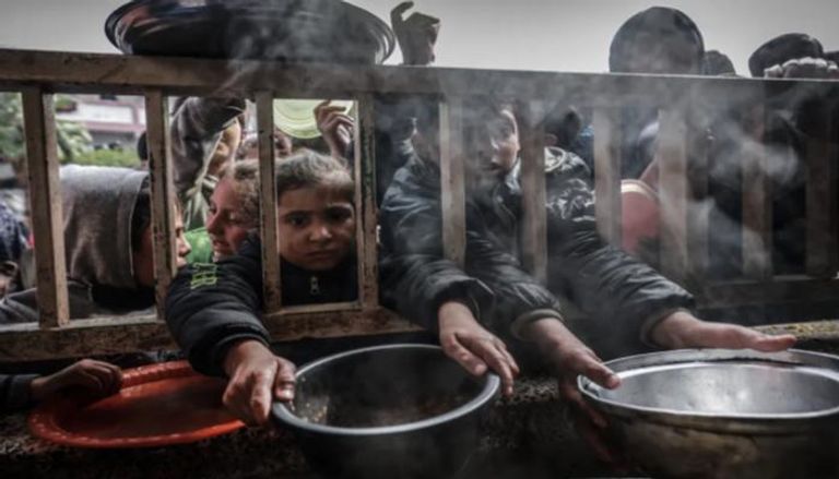 أطفال ينتظرون الطعام في غزة