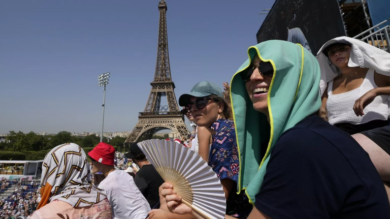 فتاة تغمس رأسها في مياه نافورة قوية للتبريد من حرارة الطقس