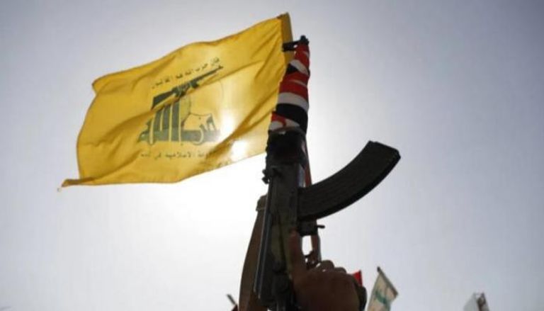 مسلح من حزب الله يحمل شعار التنظيم على بندقية