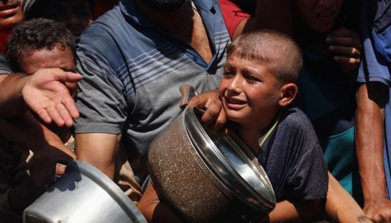 فلسطينيون يتدافعون للحصول على الطعام في خان يونس