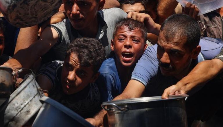 أطفال ينتظرون دورهم للحصول على وجبة من مطعم خيري بغزة