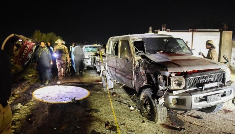 عناصر من الأمن يتفقذون السيارة بموقع التفجير الانتحاري