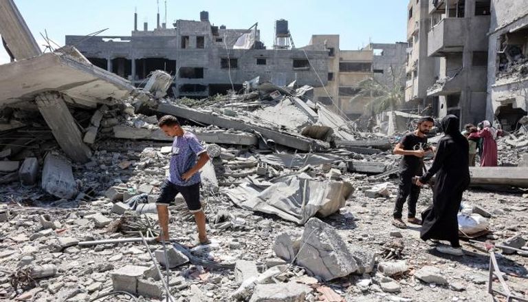فلسطينيون يتفقدون الأنقاض بعد غارة إسرائيلية على مدينة غزة