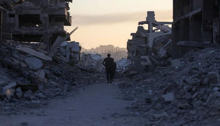 فلسطينيون وسط الركام في غزة