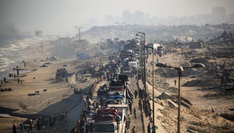 ازحون فلسطينيون مع أمتعتهم يتجهون جنوبًا على طريق في منطقة مخيم النصيرات للاجئين