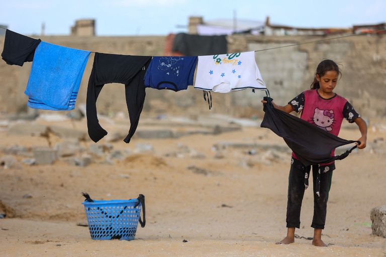 طفل يجلس فوق قبر في خان يونس