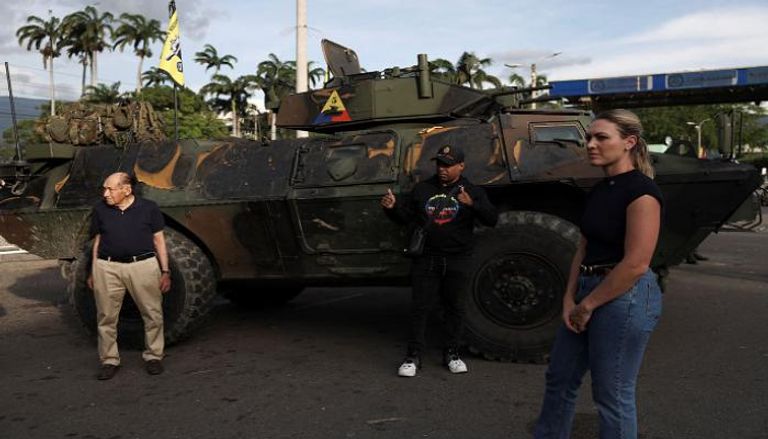 فنزويليون بجوار مدرعة عسكرية