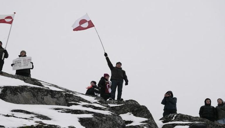 أشخاص يلوحون بأعلام غرينلاند خلال تظاهرة احتجاجا على خطط ترامب