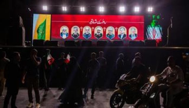 إيرانيون أمام صور لعدد من قتلى الضربات الإسرائيلية