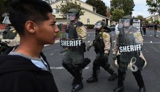 مناهض لترامب يسير جانب شرطة مكافحة الشغب بأنهايم