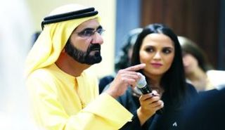 الشيخ محمد بن راشد خلال اللقاء وإلى جانبه الطالبة علياء الحموري