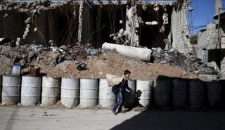 طفل يسير بجوار مبنى مهدم في دمشق - رويترز