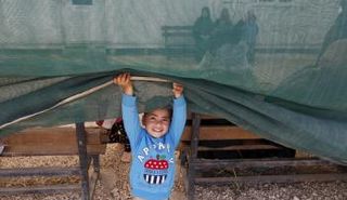 طفل سوري في أحد مخيمات اللاجئين بالأردن (رويترز)