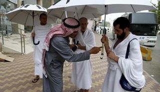 حجاج يستخدمون مظلة تعمل بالطاقة الشمسية (أ ف ب)