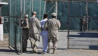 حراس يرافقون معتقلا بسجن جوانتانامو