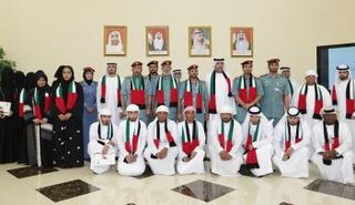 الراشدي وعدد من ضباط الداخلية يتوسطان ابناء المواطنات الذين تسلموا وثائقهم في صورة تذكارية بعد الحفل