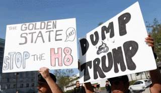 متظاهرون يحملون لافتات مناهضة لدونالد ترامب