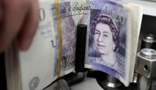 موظف بنك يعد رزمة من فئة مئة جنيه استرليني