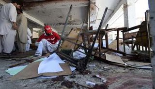 عامل إنقاذ في موقع هجوم مردان بباكستان (رويترز)