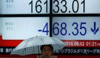 رجل يمر أمام لوحة تعرض مؤشر نيكي القياسي في طوكيو – صورة أرشيفية 