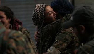 مقاتلات من قوات سوريا الديمقراطية يحضن بعضهن البعض في مدينة منبج