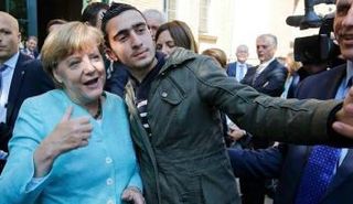 أنجيلا ميركل تلتقط سيلفي مع لاجئ سوري