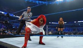 الحكم يساعد إيفا ماري على الهبوط من على الحلبة