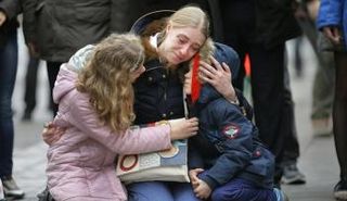 امرأة تحتضن طفليها في مراسم أقيمت حدادا على أرواح ضحايا هجمات بروكسل