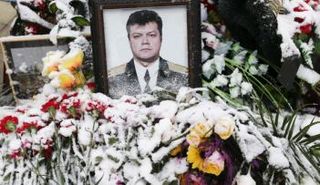 أزهار مغطاة بالثلج أمام صورة الطيار الروسي التى أسقطت طائرته  فى سوريا بصاروخ تركي