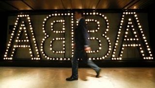 شخص يمر بشعار فريق آبا الغنائي السويدي لموسيقى البوب في ستوكهولم