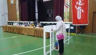 كويتية تدلي بصوتها في أحد مراكز الاقتراع بالعاصمة