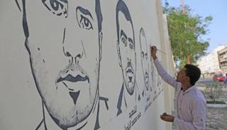 فنان يتابع عمله في رسم الجدارية