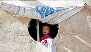 طفلة عراقية بمخيم للنازحين تنظر إلى المجهول