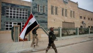 جندي عراقي يحمل علم بلاده في الموصل