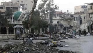 مسجد مدمر في شارع مهجور مملؤ بالحطام في دير الزور