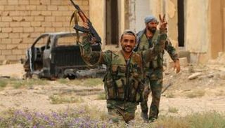 جندي تابع لقوات سوريا الديمقراطية يرفع علامة النصر - أ.ف.ب