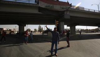 مواطنون يرفعون العلم العراقي فى كركوك- أ.ف.ب