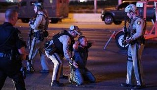 الشرطة تفتش أحد الأشخاص عقب الحادث- أ.ف.ب