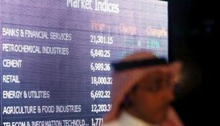 متداول أمام شاشة عرض لسوق المال السعودي