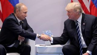 الرئيس الأمريكي ترامب يصافح نظيره الروسي بوتين (رويترز)