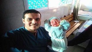 الطبيب المصري محمد نافذ مع الطفل فور ولادته 