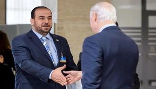 نصر الحريري (إلى اليسار) يصافح وسيط الأمم المتحدة ستافان دي ميستورا