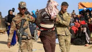 ضباط يقتادون داعشيًا تخفى وسط النازحين 