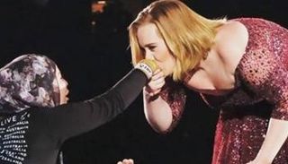 المطربة البريطانية أديل تقبل يد فتاة مسلمة